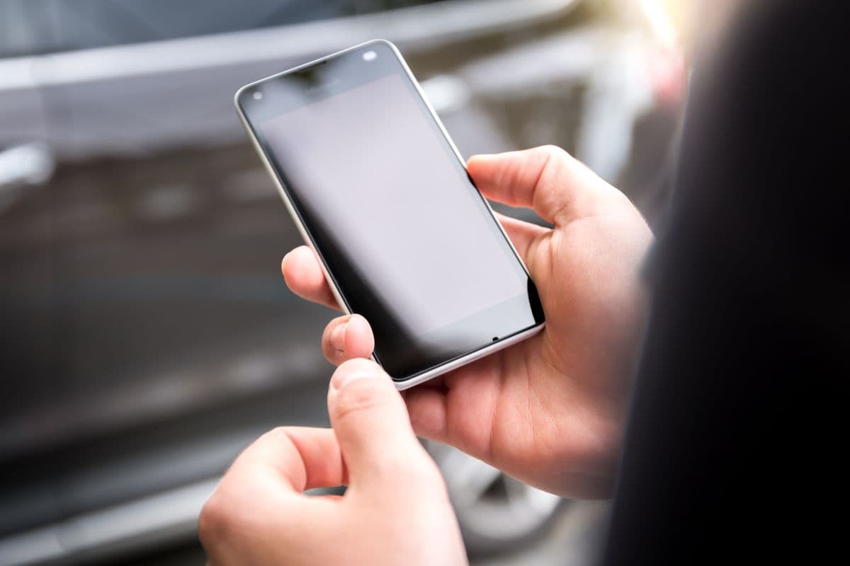 A person holding a smartphone, representing the mobile visitors who abandon slow-loading pages